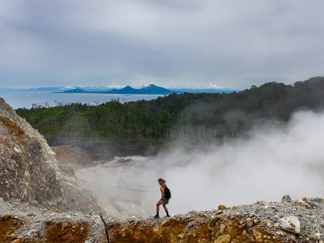 Escursionista tra le fumarole e le esalazioni vulcaniche del vulcano Garbuna